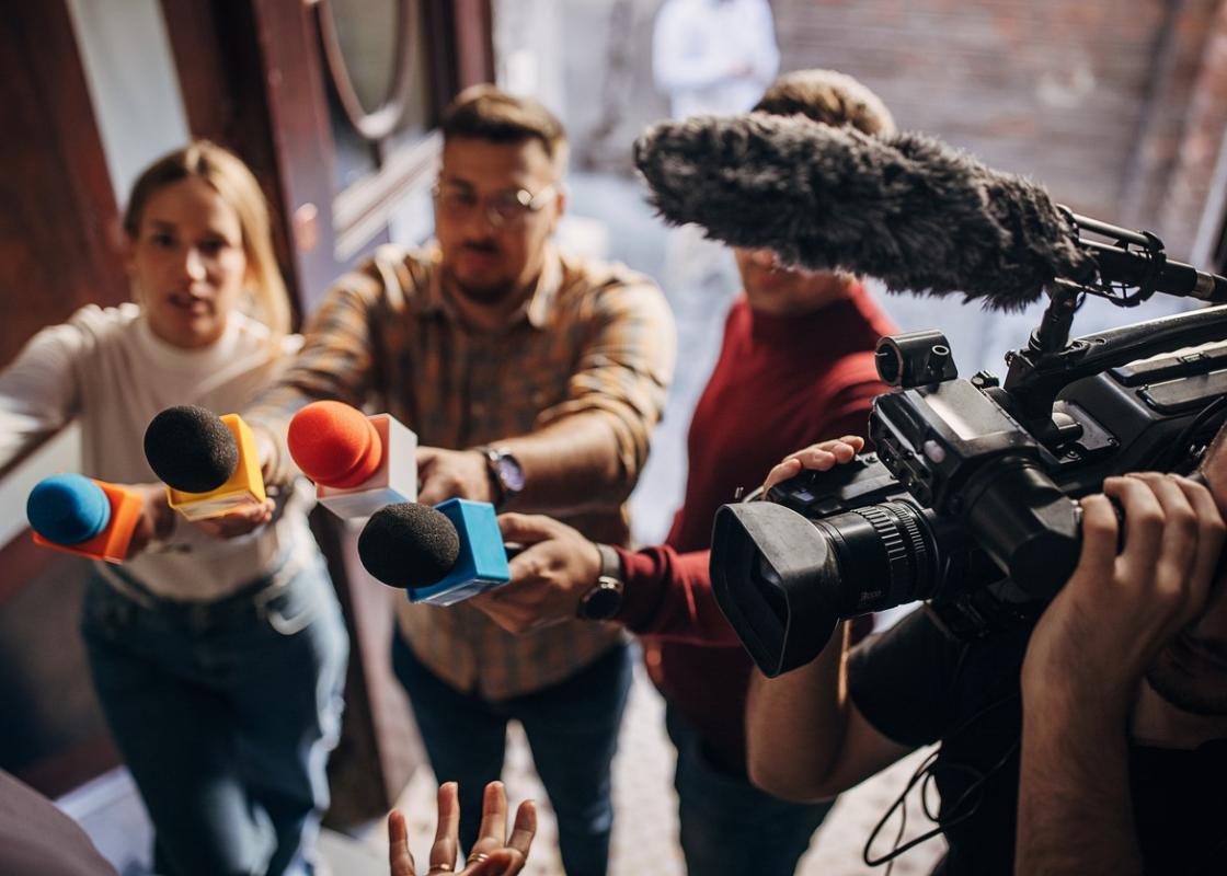 Journalister retter mikrofoner og kamera mot intervjuobjekt