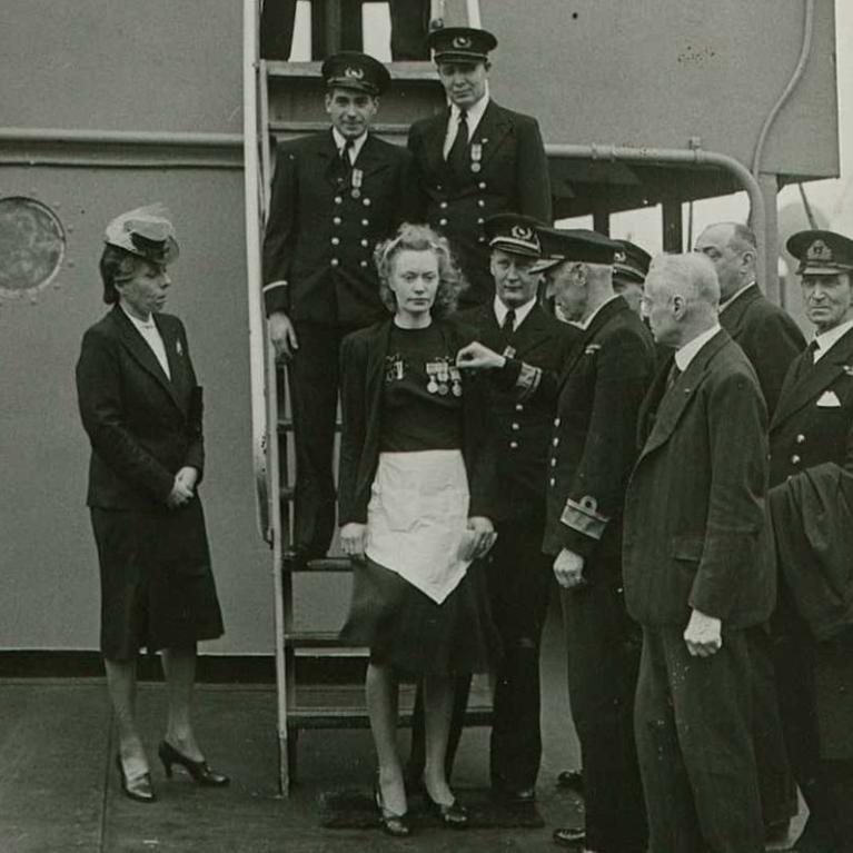 Margit Johnsen dekoreres for sin innsats under 2. verdenskrig. Kapteinen står til høyre for Margit, admiral Ritchie foretok dekoreringen. Til høyre for admiralen er den norske konsul i Liverpool, Johan Vogt, som foretok dekoreringen fra norsk side.